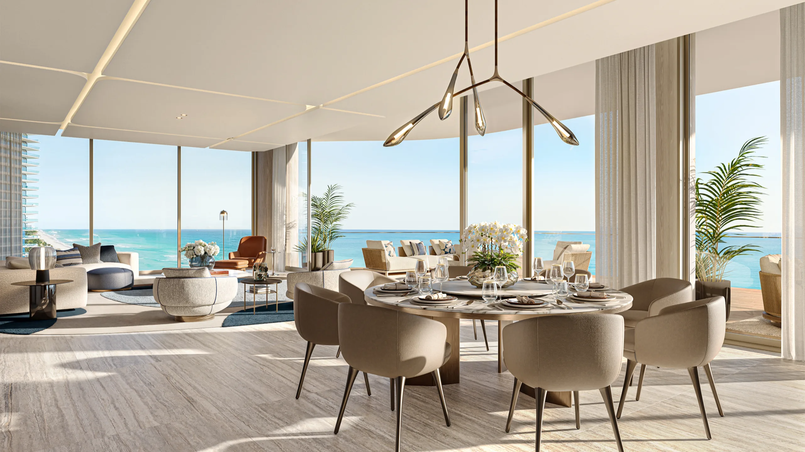 Modern dining room with large windows overlooking the ocean and a stylish chandelier
