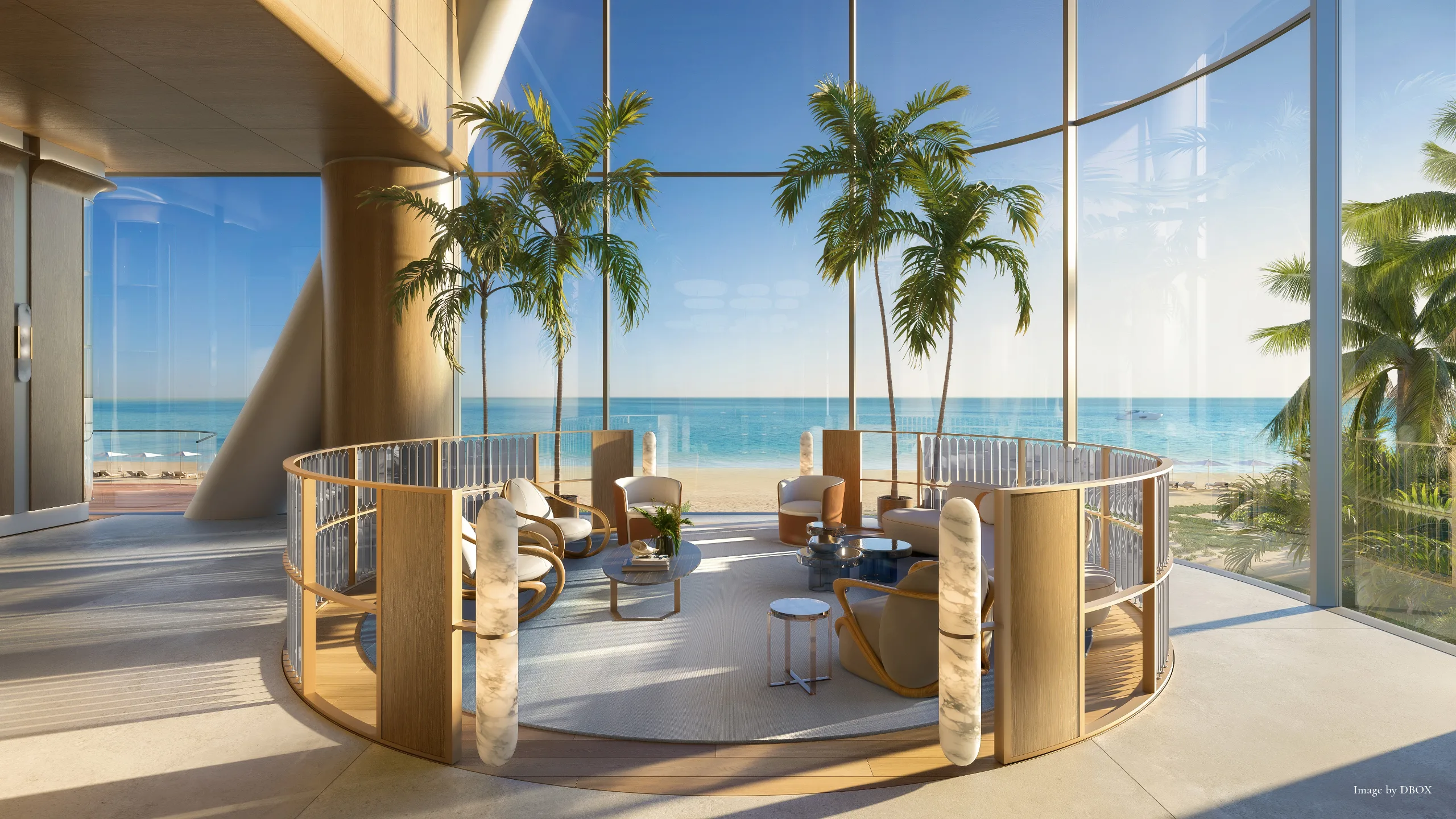 Indoor lounge area with large glass windows overlooking the beach and ocean, featuring palm trees and modern furniture