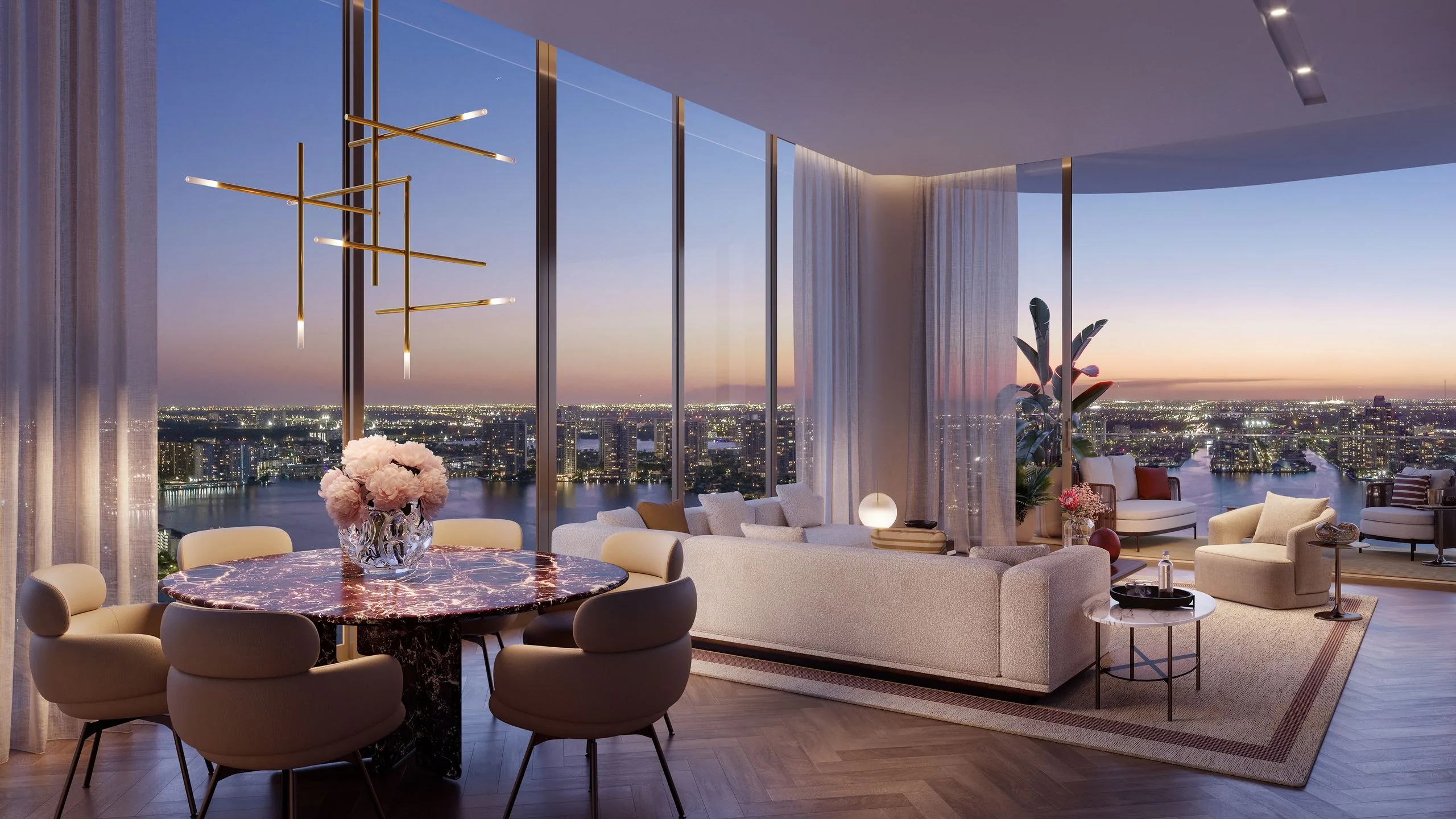 Living room with large floor-to-ceiling windows overlooking a city skyline at sunset