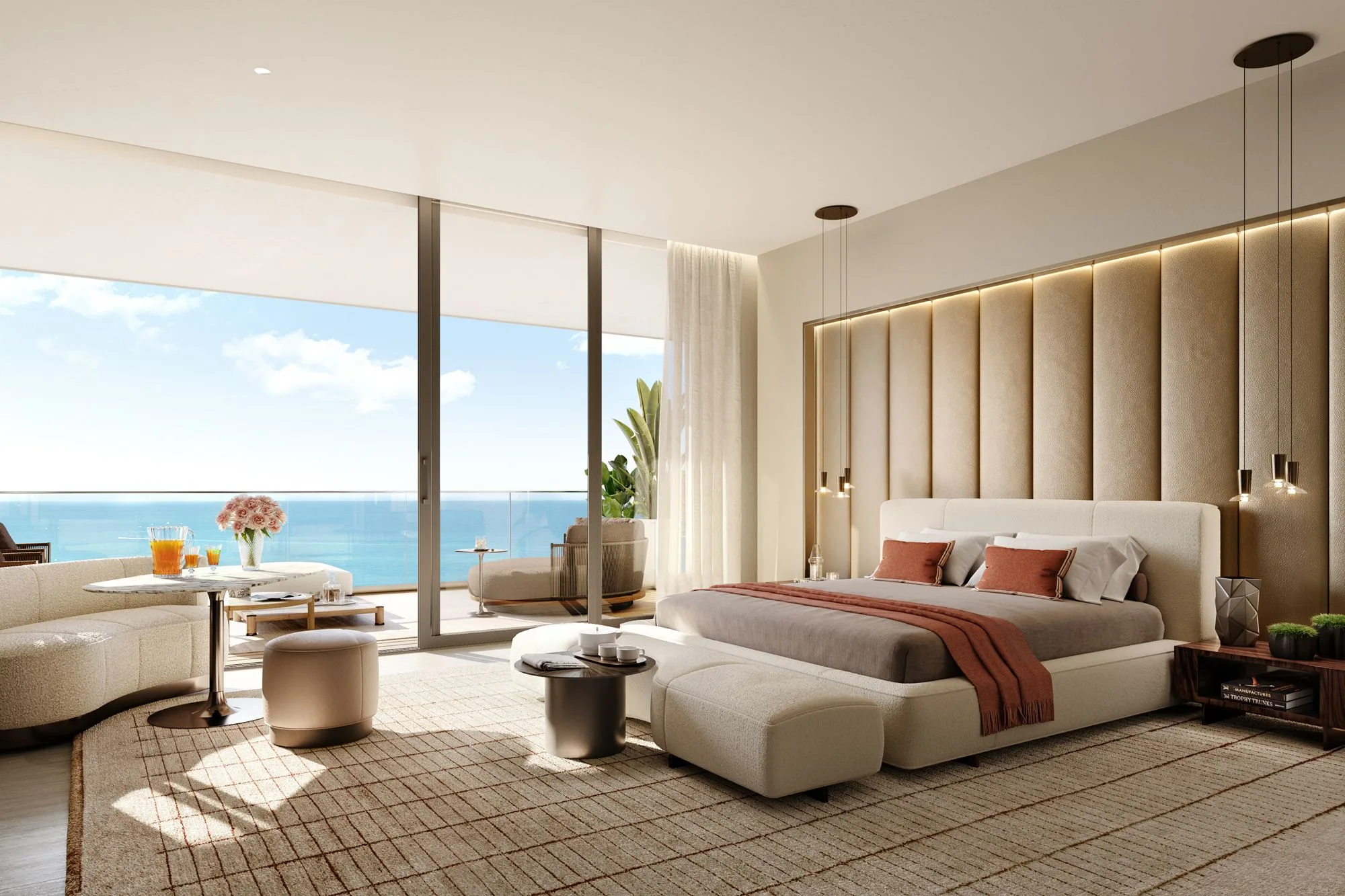 Modern room with large glass doors opening to a balcony overlooking the ocean